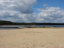 Szeroka plaża z kąpieliskiem i pomostami. Jezioro Sławskie, maj 2015